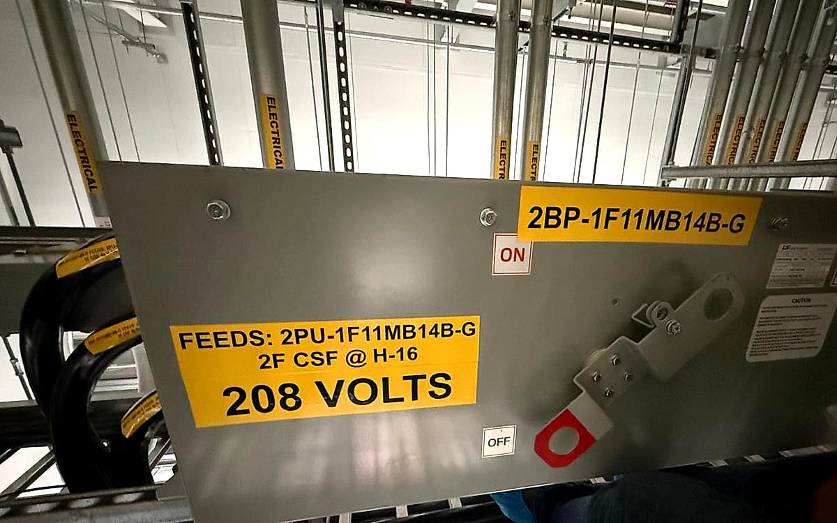 Labeled 208 volt busway tap-off unit feeding a data center power distribution circuit, with lockout provision and circuit identification tags