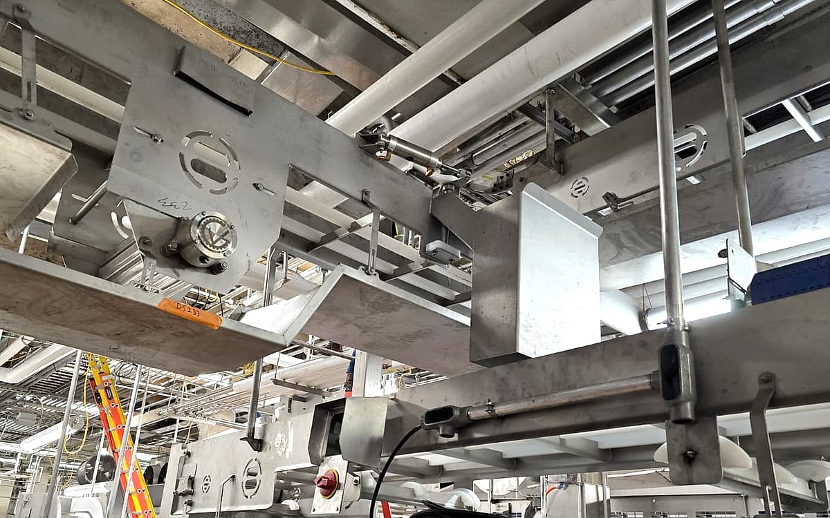 Stainless steel overhead conveyor and sanitary process equipment being installed in a processed food production facility